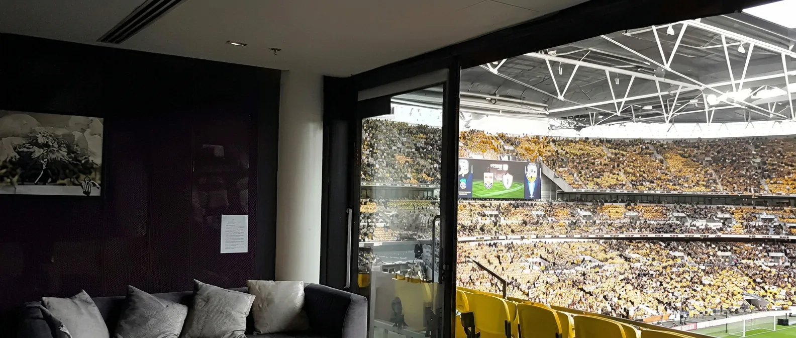 Private stadium box with lounge seating overlooking a full matchday crowd