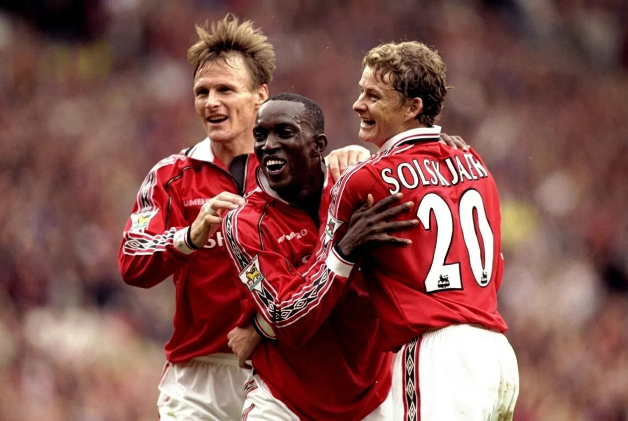 Premier League legends celebrating together on the pitch